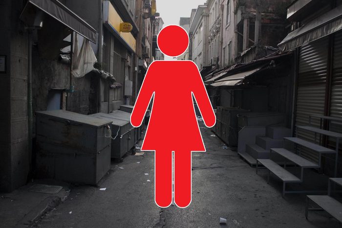 dirty, empty alleyway with woman symbol overlay
