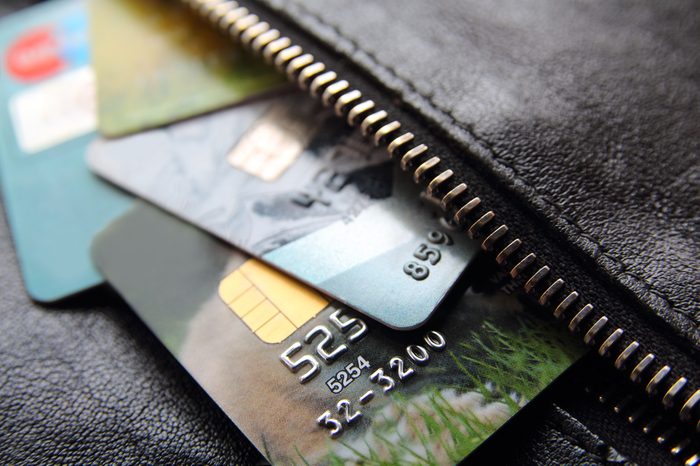 Credit cards peeking out of the black leather bag or purse, close-up.