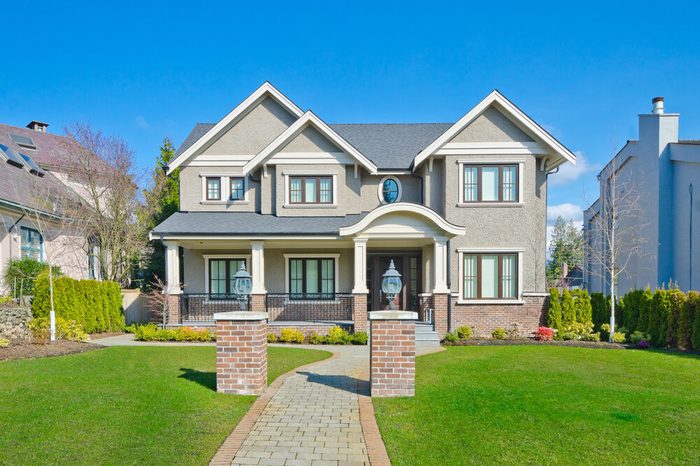 Big custom made luxury house with long doorway and nicely trimmed front yard in the suburbs of Vancouver, Canada.