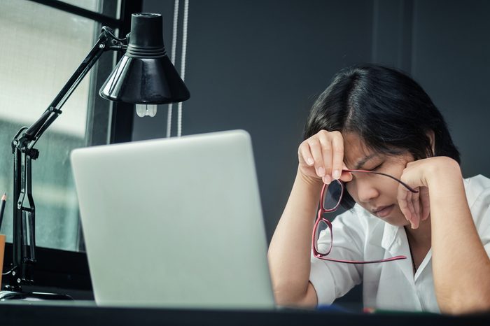 Close up of asian girl thinking about work. Glasses girl be ill. Business woman having headache and migraine. Exhausted and tired, stressed of businesswoman.
