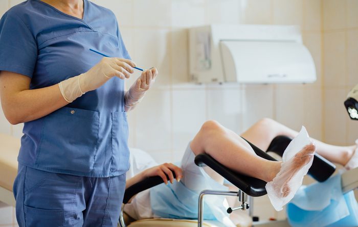 Unrecognizable female doctor gynecologist working with patient. Vaginal Smear.