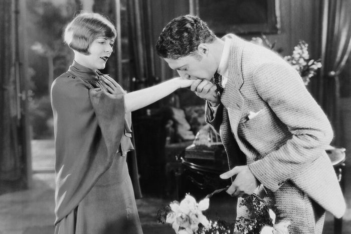 Man with flowers kissing womans hand