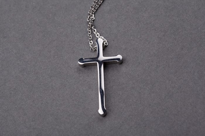 Silver cross on a gray background close up image