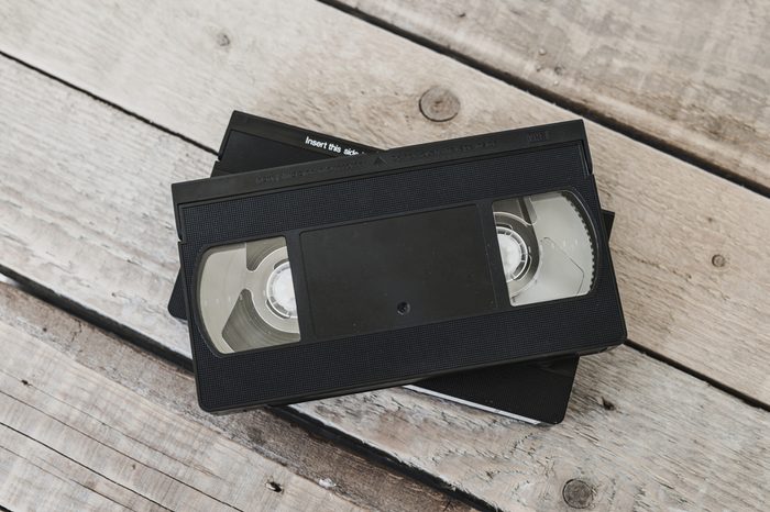 stack of VHS video tape cassette on white wooden table, retro filter