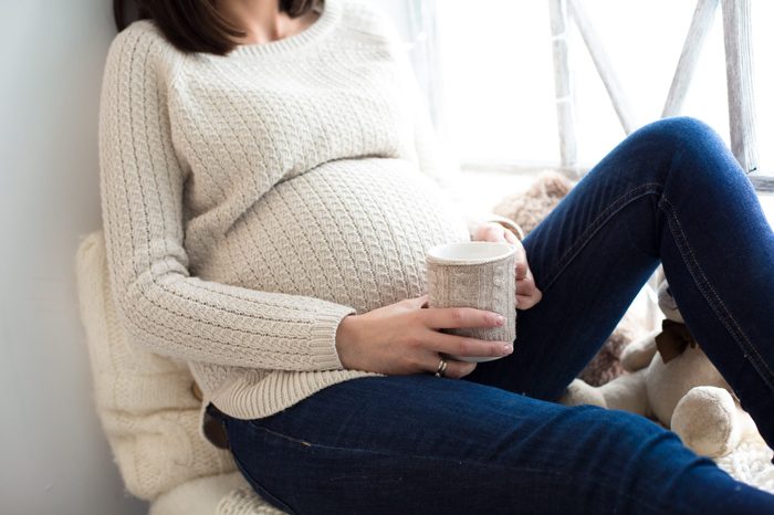 Pregnant woman with a cup in his hands