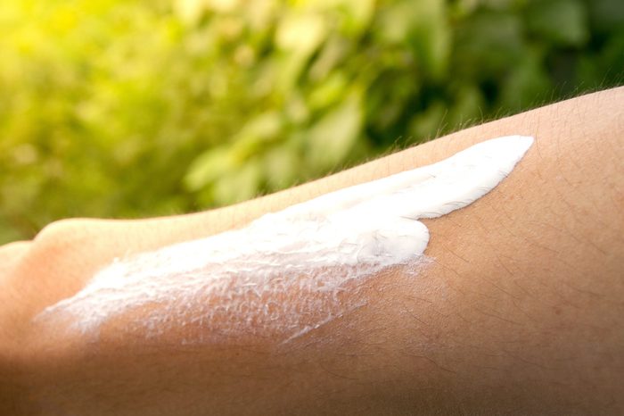 Close up sunscreen ,sun block on man's arm