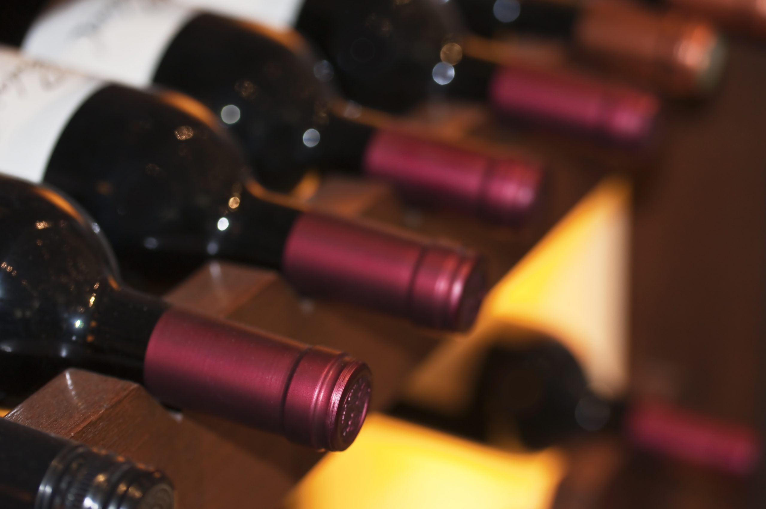 Bottles of red wine on a wooden shelf