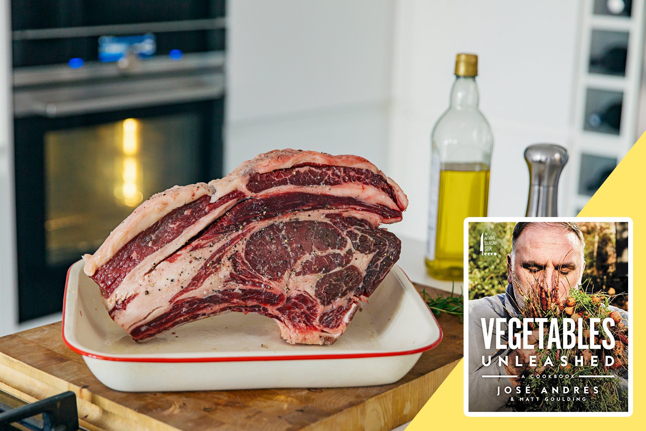 Raw rib roast rests in a pan; nearby, a cookbook titled "Vegetables Unleashed" by JosÃ© AndrÃ©s and Matt Goulding. A kitchen setting provides context.