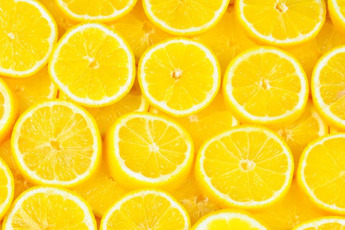 A slices of fresh juicy yellow lemons. Texture background, pattern.
