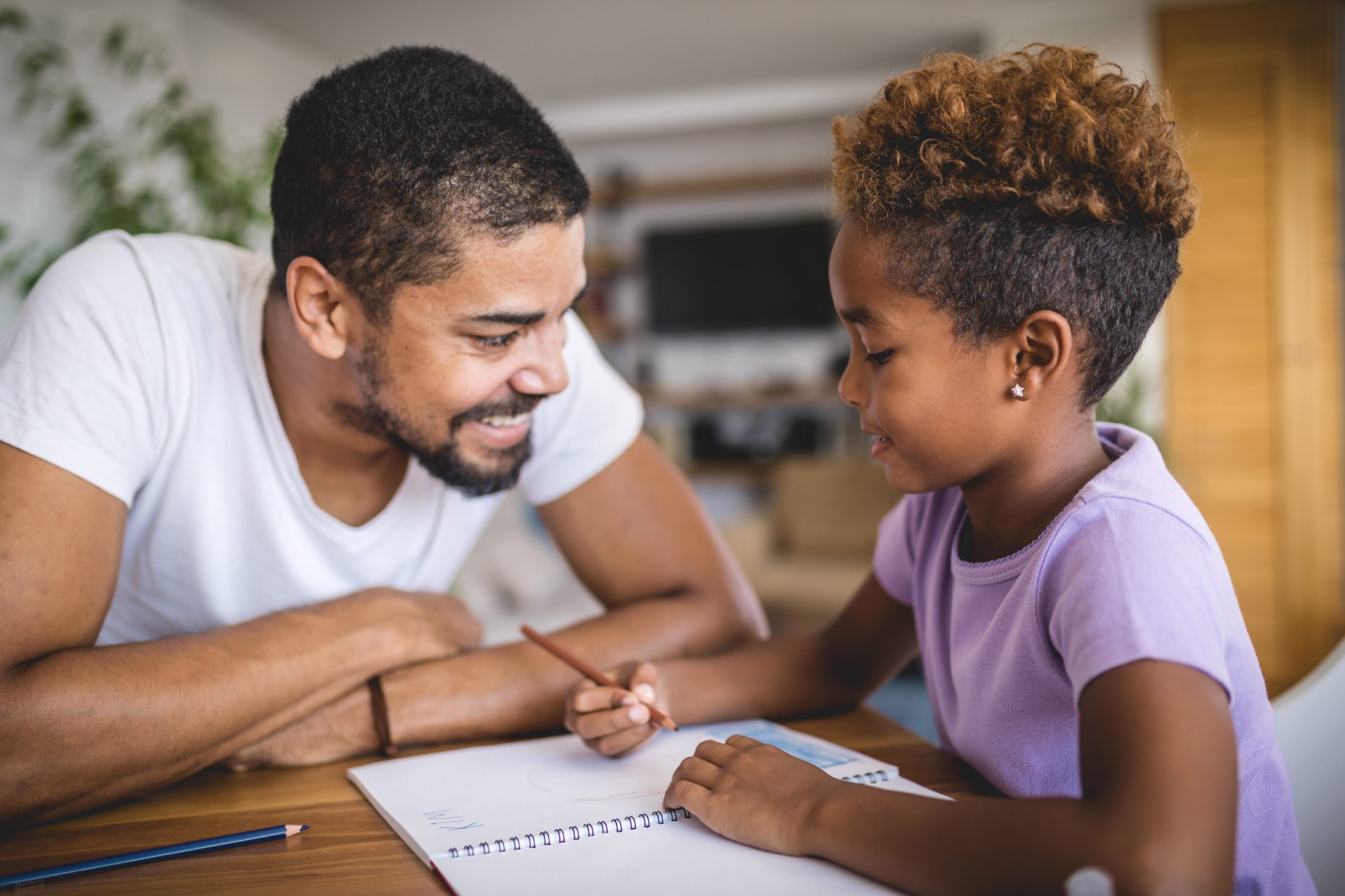 Lovely daughter and father doing homework