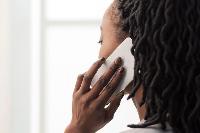 Unrecognizable Businesswoman Talking On Cellphone In Office, Closeup
