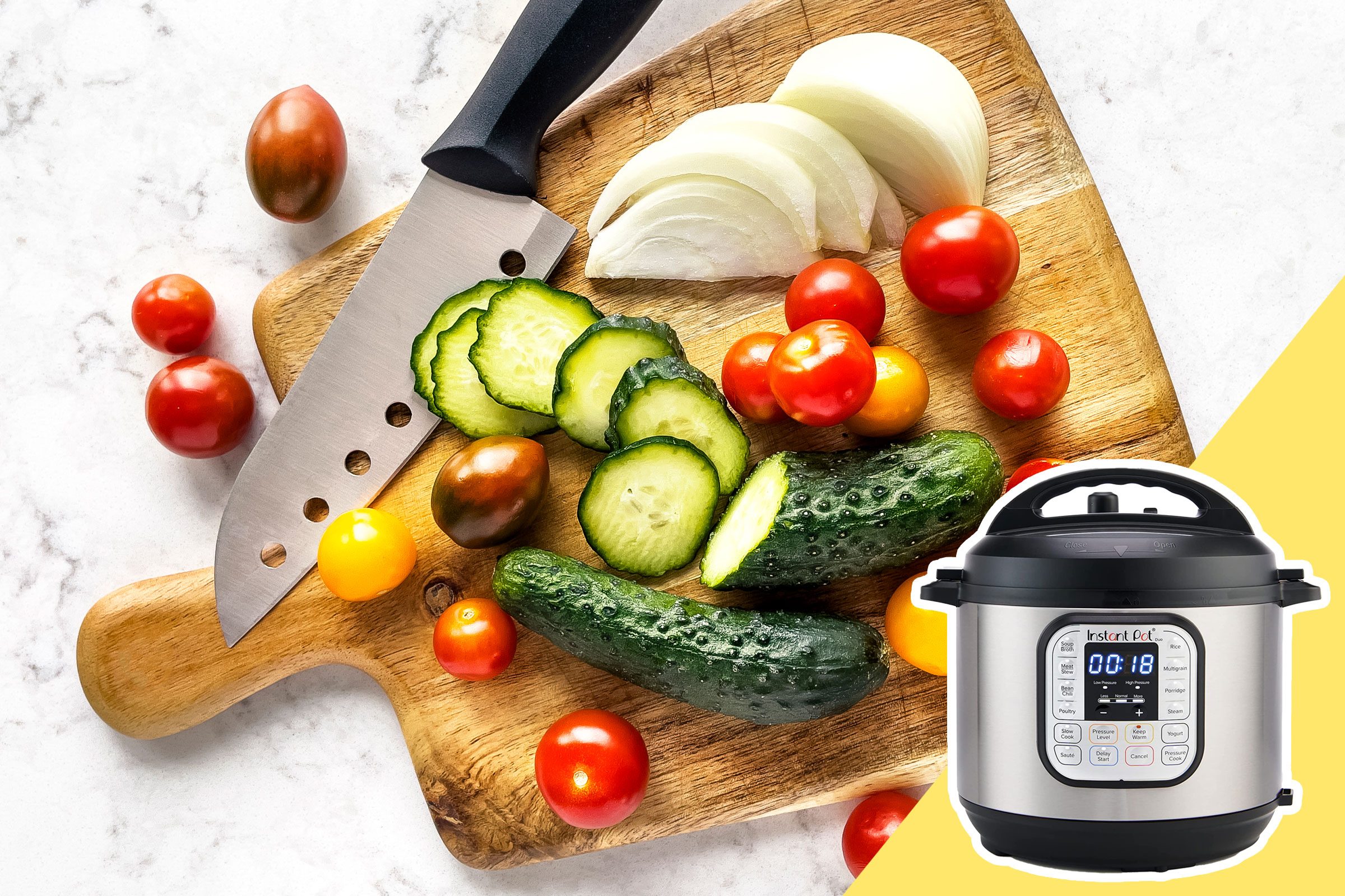 Knife rests on cutting board, slicing cucumbers among tomatoes and onions; an Instant Pot stands nearby on a marble surface.
