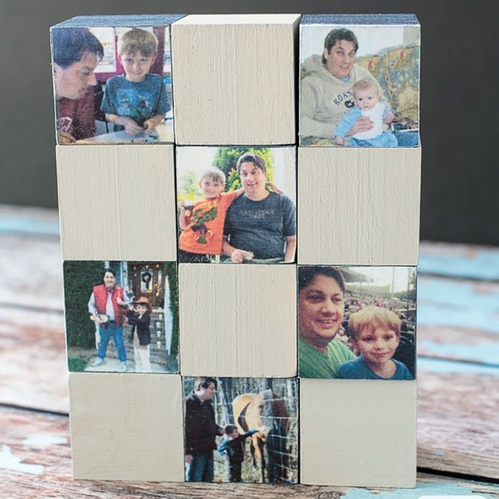Wooden blocks display family photos, forming a grid on a rustic wooden surface.