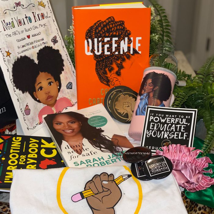 Books and merchandise displayed on a table with plants; items include books 