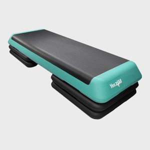 An exercise stepper with a black platform is positioned on stackable risers, featuring a teal border and 