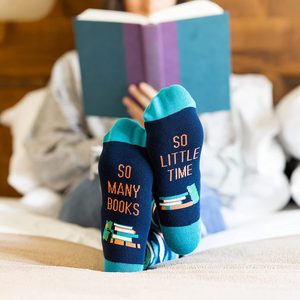 Socks display text while reading a book, relaxing on a bed. Text reads: 