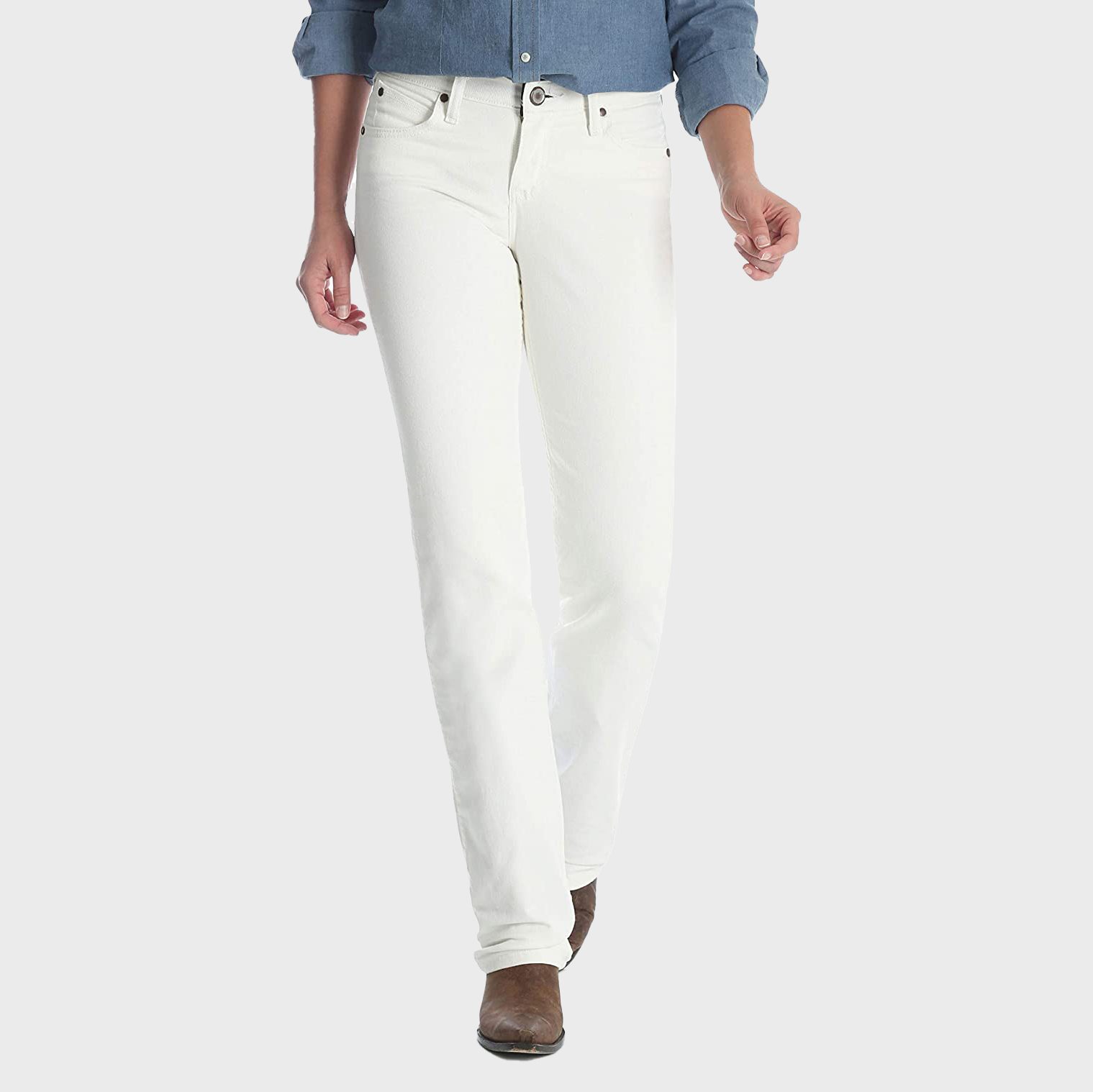 Person wears white jeans and a denim shirt, walking forward on a plain light background. Brown shoes are partially visible.
