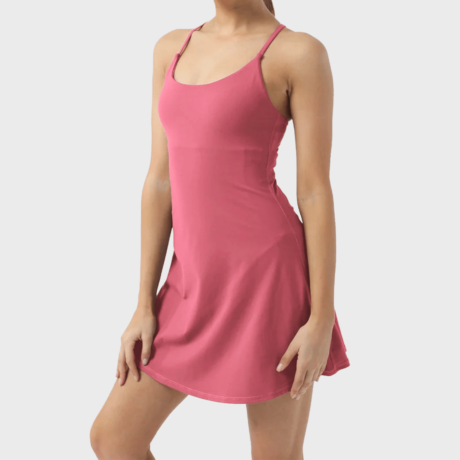 A person wears a pink sleeveless dress with thin straps, standing against a neutral background.