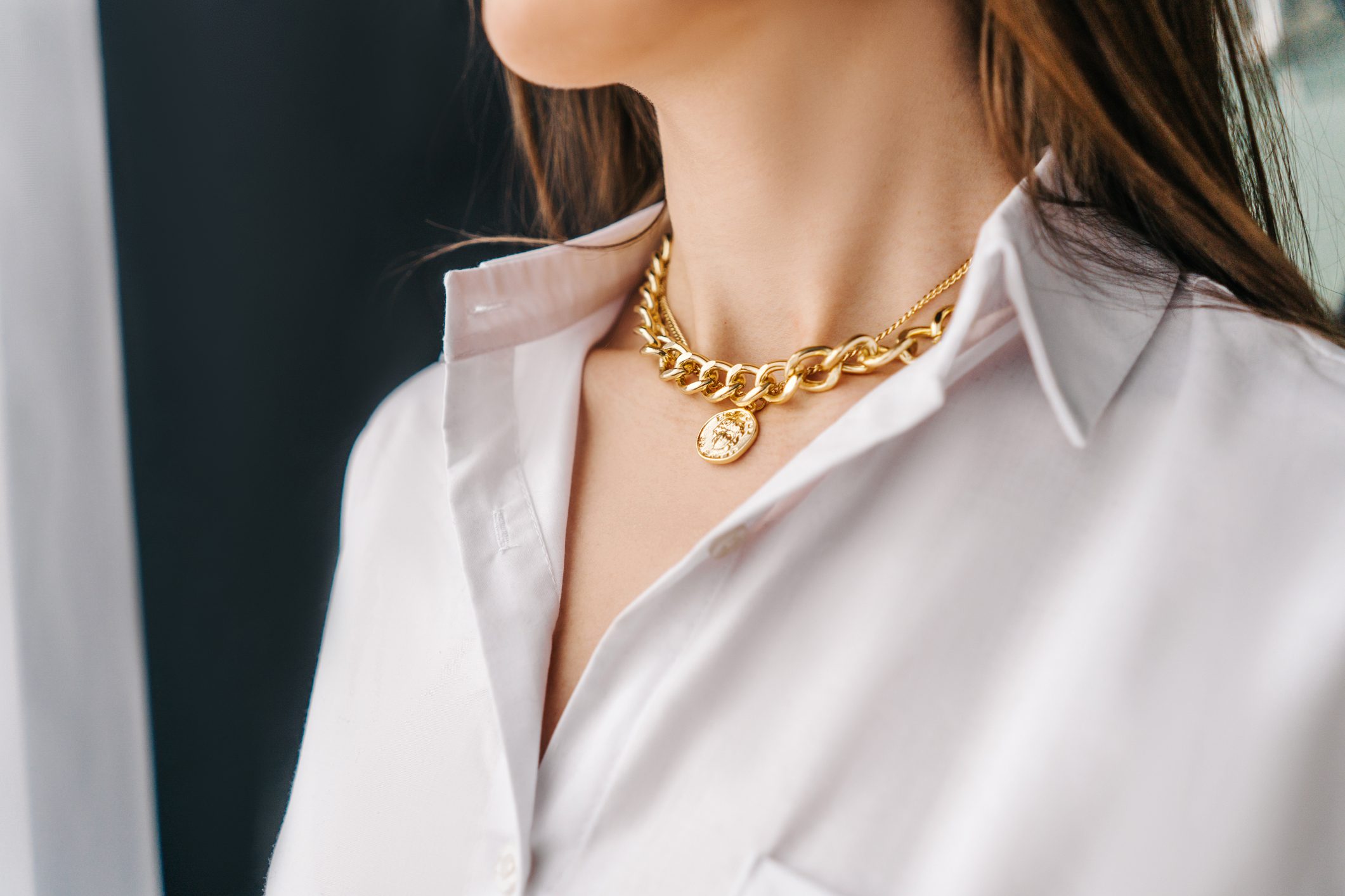 Silver bijouterie chain on woman neck. Close-up.