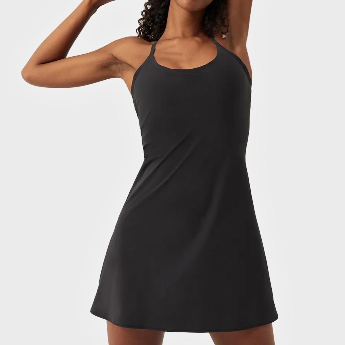 Person wearing a sleeveless black dress, raising one arm, against a plain white background.