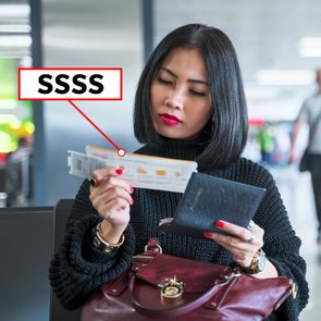 A woman examines a boarding pass marked with 
