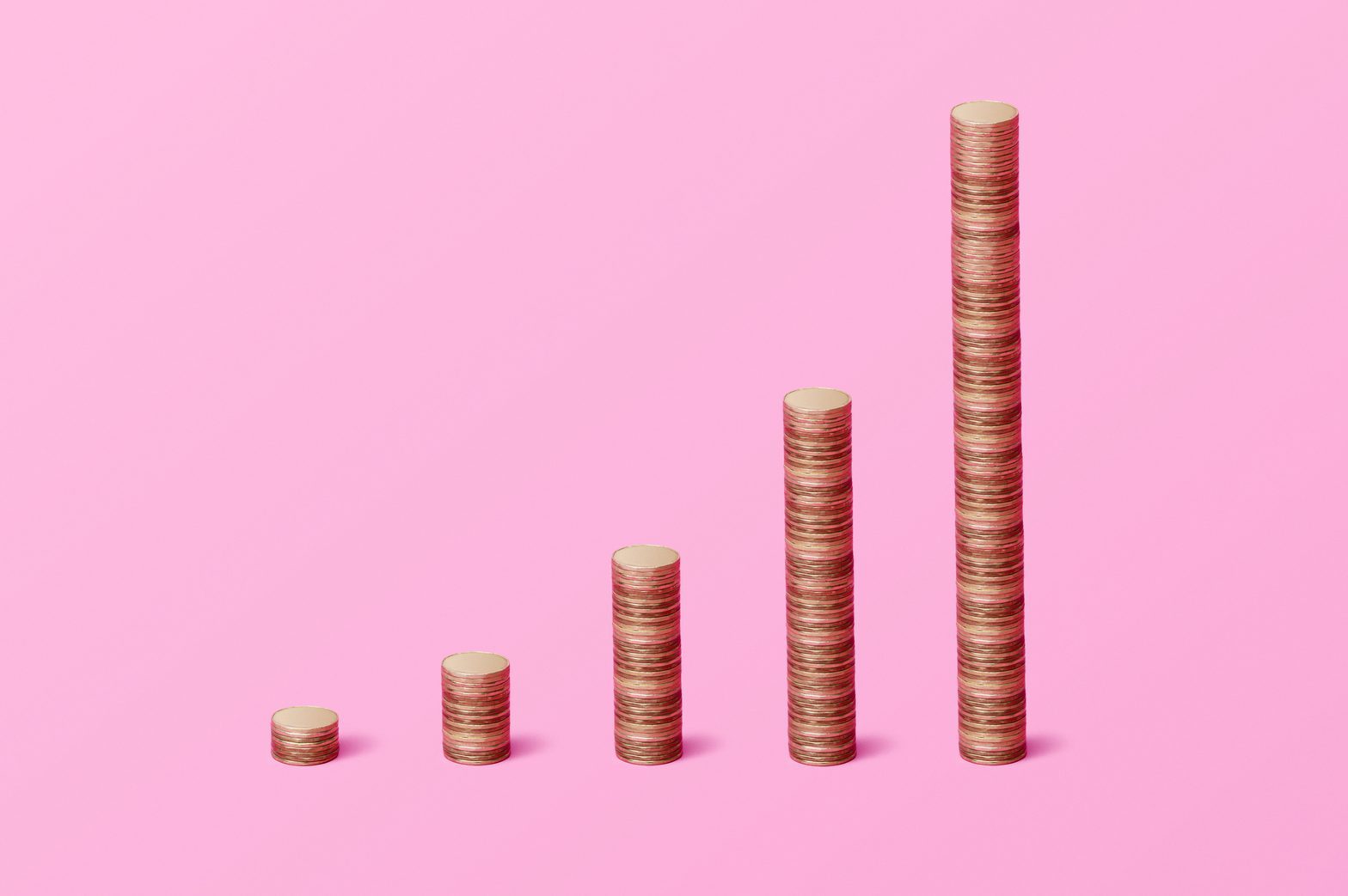Stacks of coins arranged in ascending order on a pink background.