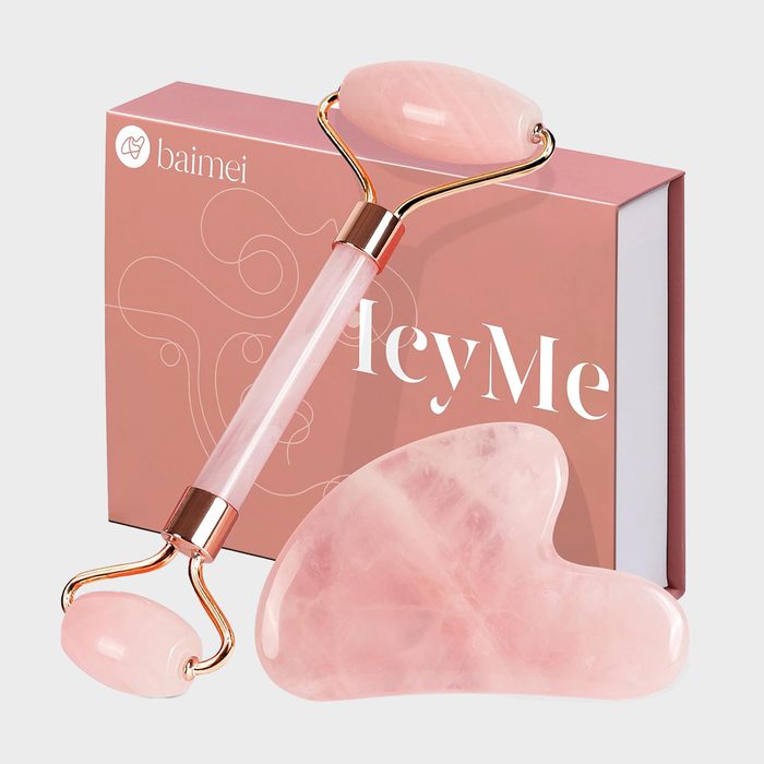 Pink facial roller rests on a pink box labeled 