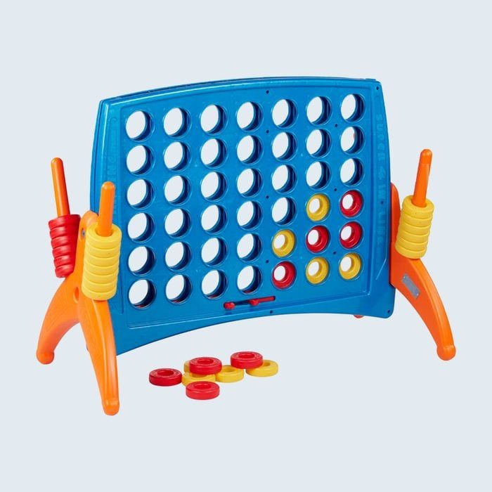 Blue Connect Four game board stands, holding red and yellow disks in a mix of slots. Disks lie scattered below on a plain background.