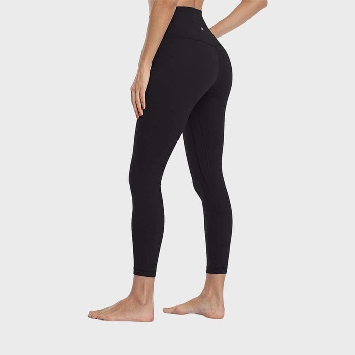 Leggings cover a standing person's lower body, showcasing barefoot stance on a plain, light background.