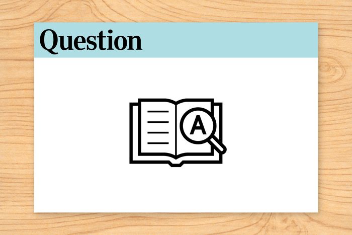 Book with magnifying glass icon, letter "A," beneath "Question 20" text, set on wood-textured background.