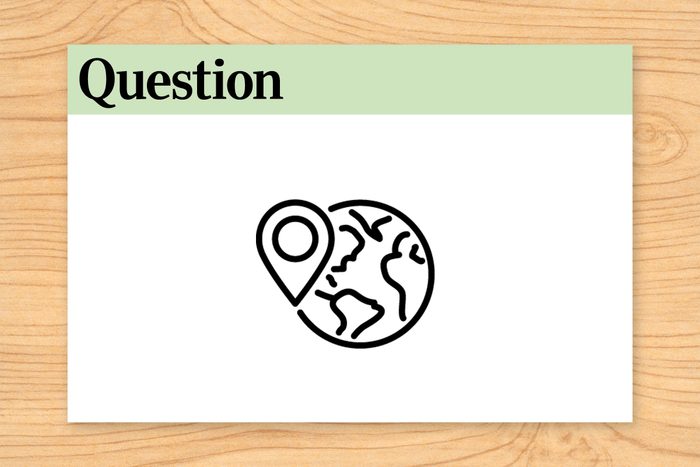 Location marker overlays globe illustration; bordered by "Question" and number "7," set against a wooden background.