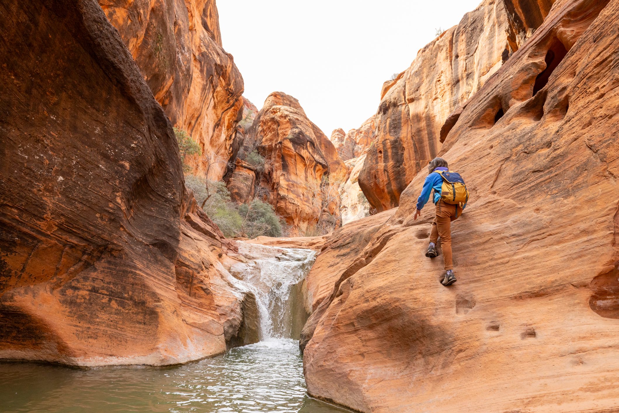 A woman hiking a slot canyon in the desert of Utah