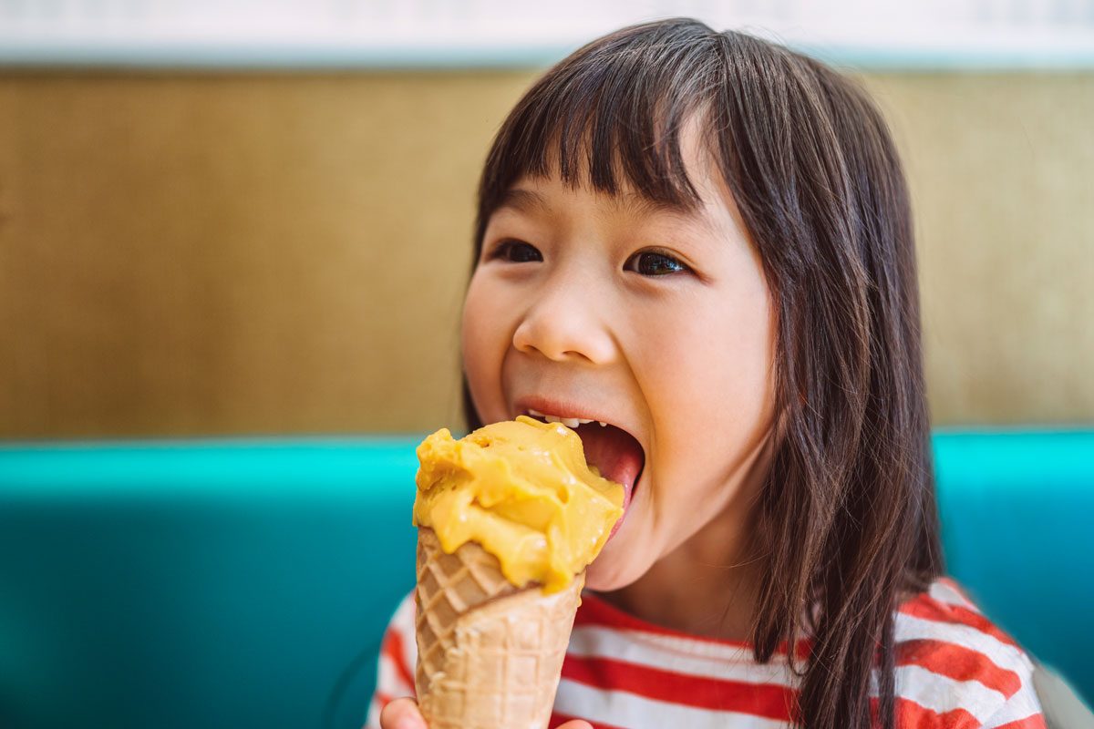 Lovely Cheerful Girl Enjoying Ice Cream